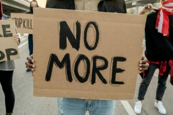 resistance Protestor holding a cardboard sign with No More
