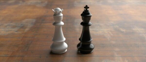 chess pieces Black king and white queen chess pieces on a wooden surface represent contrasting leaders from X and Y theory