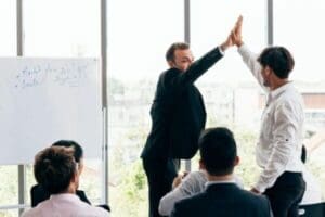 HR manager giving high five to employee during conference discussing 2025 Workplace Trends
