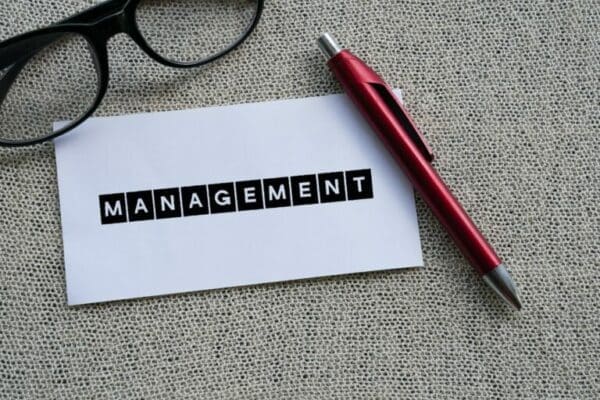 MANAGEMENT The word MANAGEMENT on white paper with a red pen