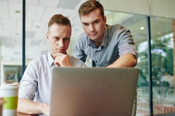 Manager helping work colleague on a laptop Manager helping work colleague on a laptop