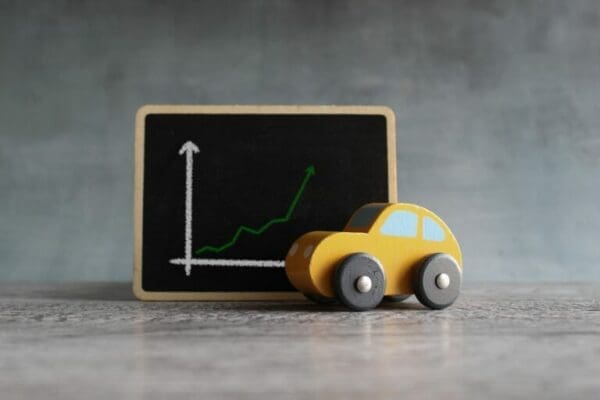 Toy car next to upward graph representing drivers for employee retention strategies