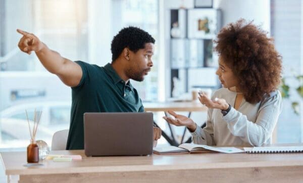 work partners during a conflict are arguiing over a laptop