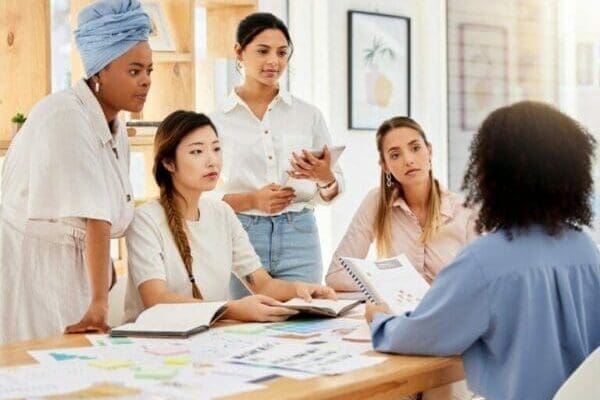 Female leader Female leader talking with her team around a desk