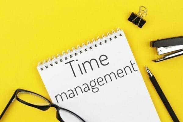 Time management notebook with word time management on a yellow background