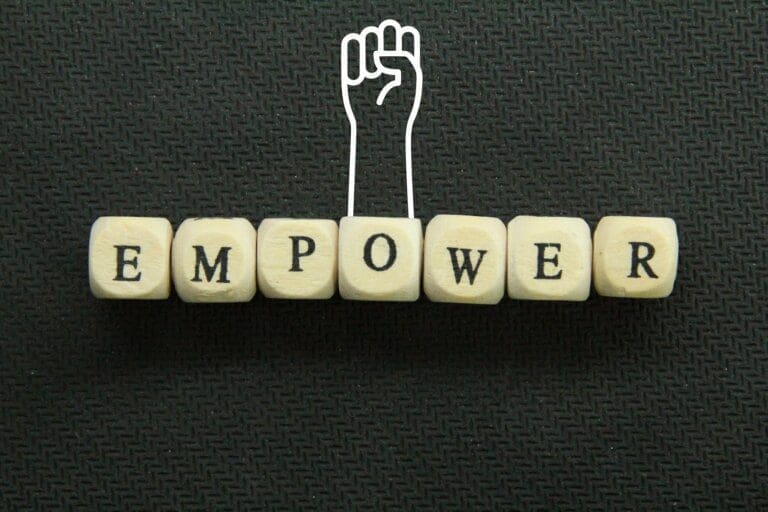 empower the word empower on a wooden cube with hands up