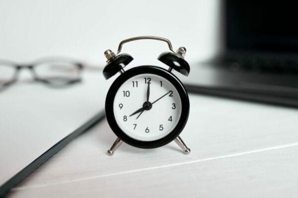 Black clock on clean office desk