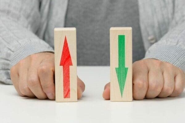 Female hand holds wooden blocks with up and down arrows