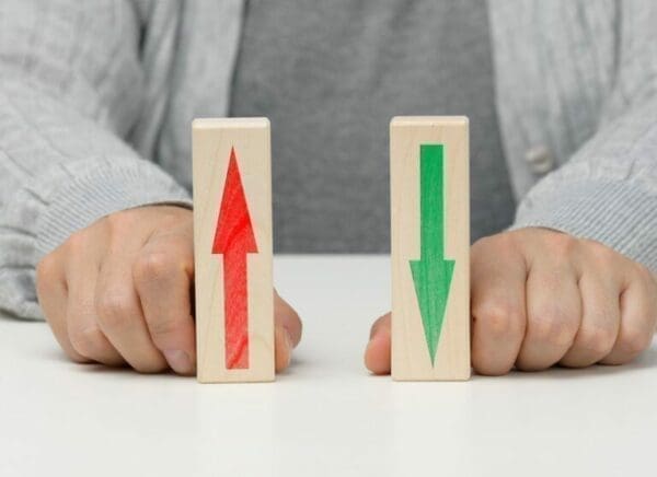 up and down arrows Female hand holds wooden blocks with up and down arrows
