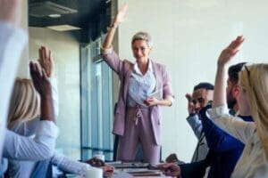 Female coach speaking in front of group of happy managers