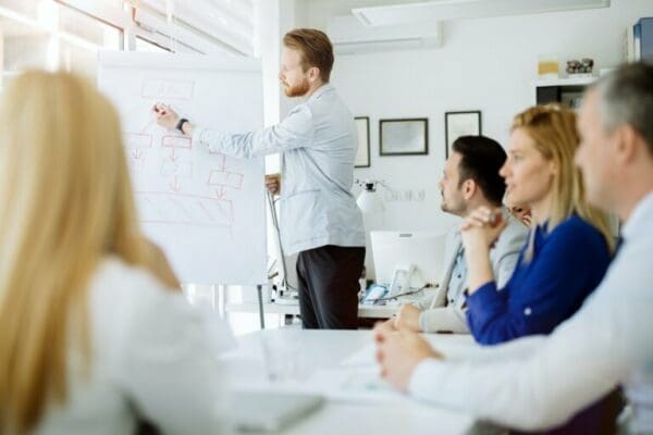 Businessman public speaking with aid of flipchart