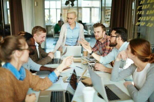 Group of managers around a table with female coach