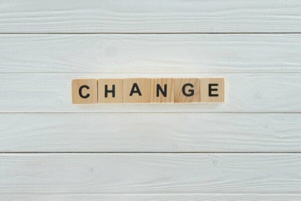Change spelled with wooden cubes on white wooden tabletop