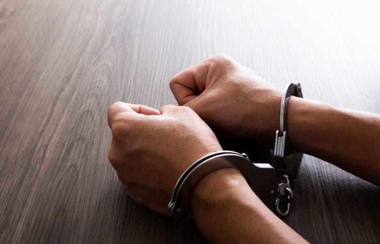 Criminal hands locked in handcuffs as punishment