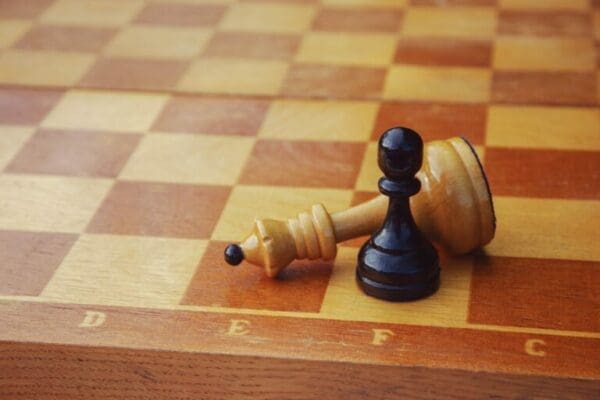 Knocked over chess piece representing weakness