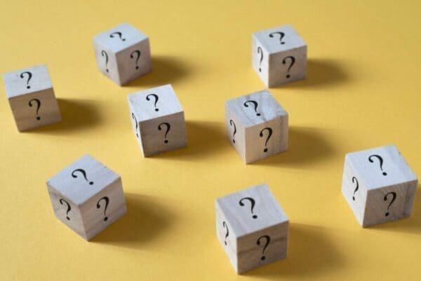 Wooden cube box with question mark on yellow background