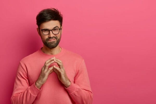 Man giving an evil expression with pink background