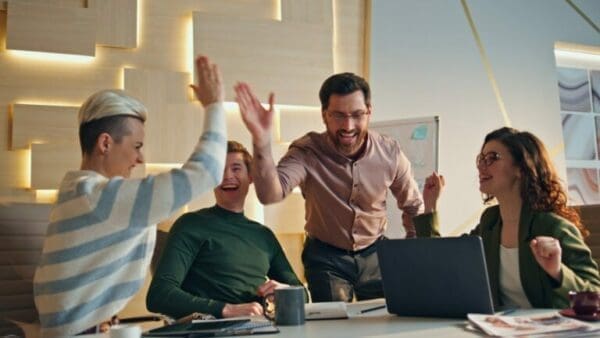 team Successful team giving five rejoicing business achievement in conference room.