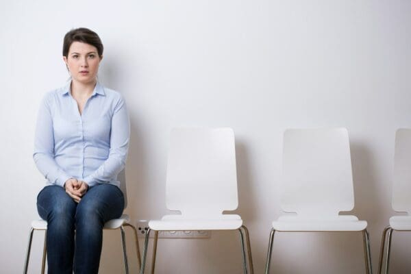 A woman at the end of a row of chairs waiting for an interview