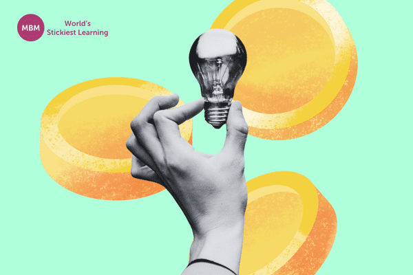 Hand holding a lightbulb with coins in the background