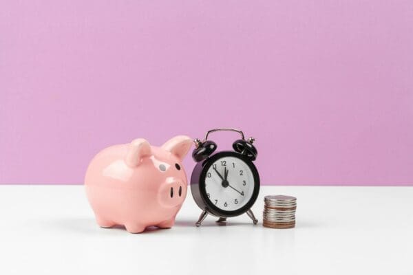 piggy bank with coin on the table with pink background