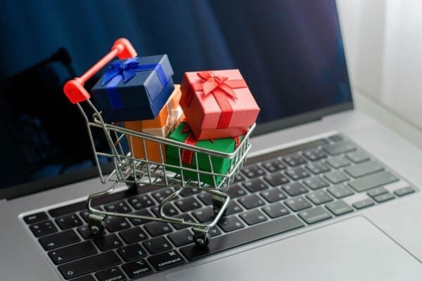 Mini gift boxies in mini shopping trolley on a laptop