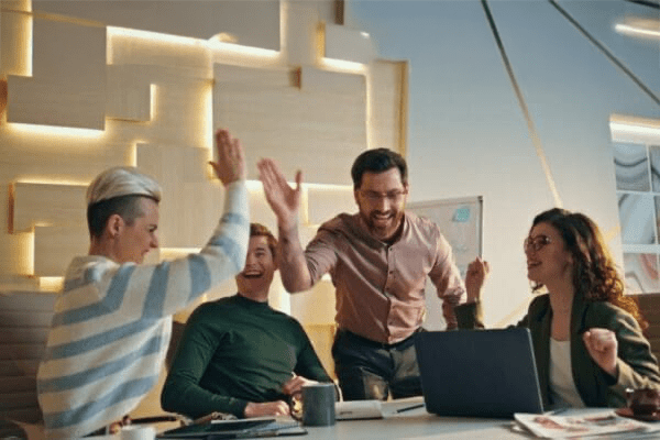 Successful team giving five rejoicing business achievement in conference room.