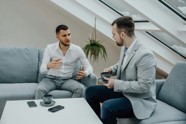 Two Men Asking Each Other Coaching Questions over Coffee