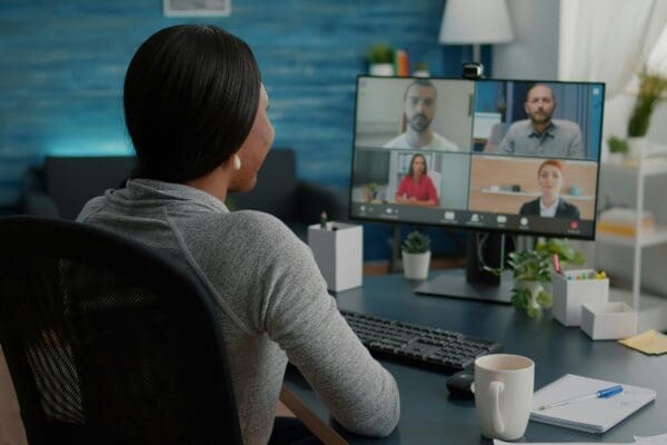 Woman sat at a desk on an online recurring meeting