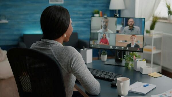 Woman sat at a desk on an online recurring meeting